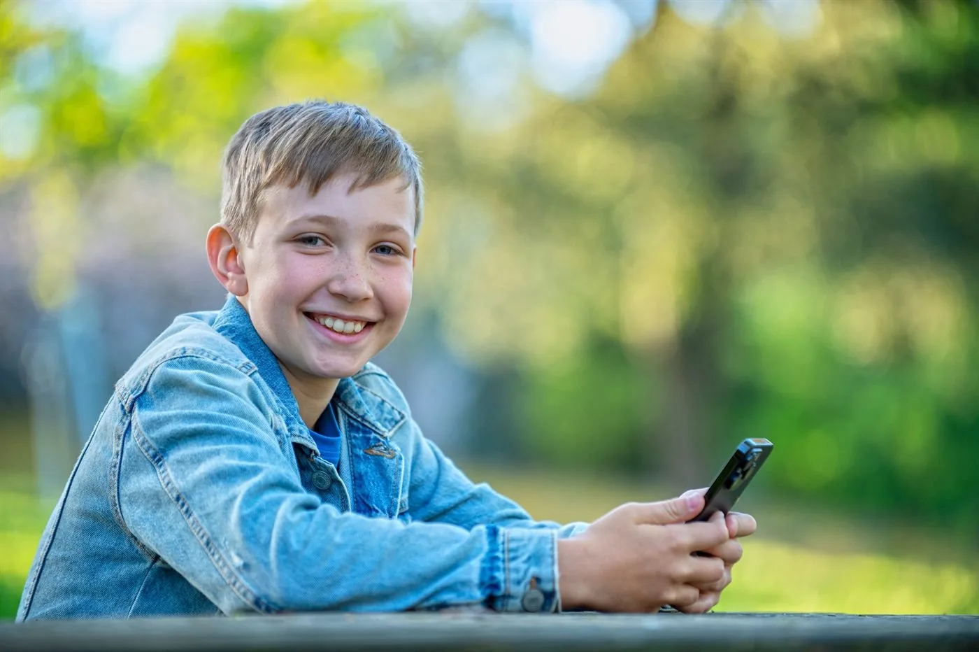 A child enjoying their phone safely, outdoors